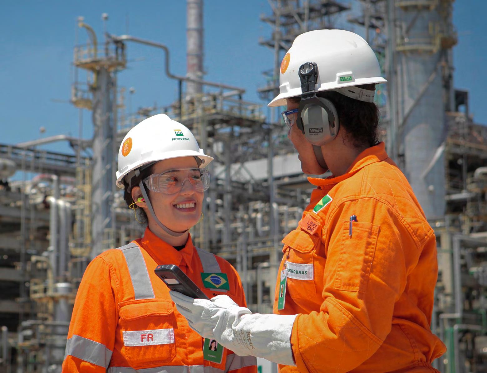 Foto de duas colaboradoras da Petrobras conversando no ambiente de trabalho.